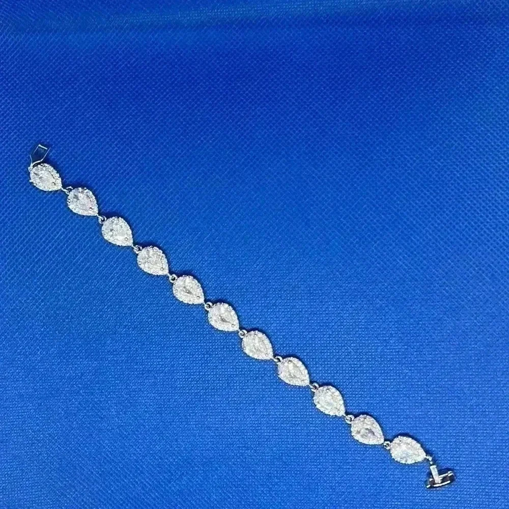 Pear shape cubic zirconia bracelet with halo mounting.